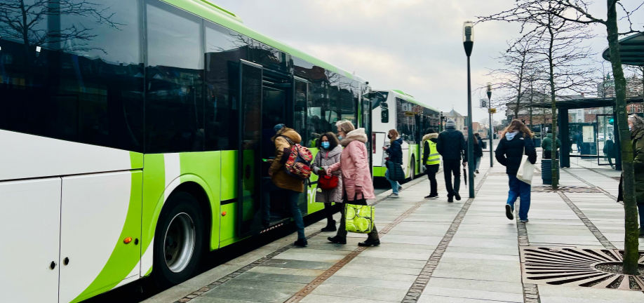 Mange mennesker er på vej ind i to busser, der holder foran et fortov. Svendborg Busterminal.