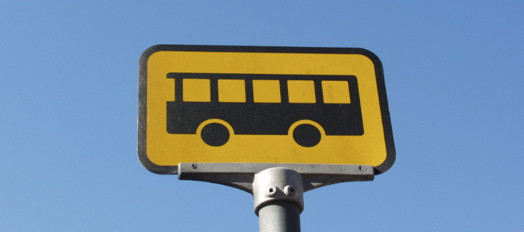 Et gult skilt med et ikon af en sort bus.