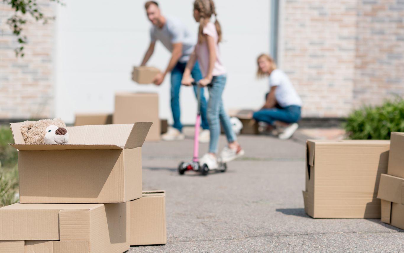 Familie med flyttekasser i indkørsel