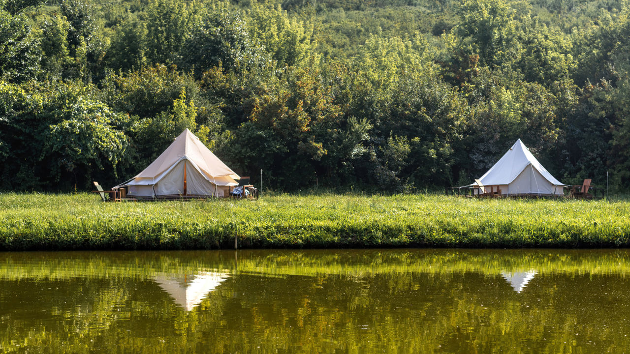 Grønt landskab med to glampingtelte