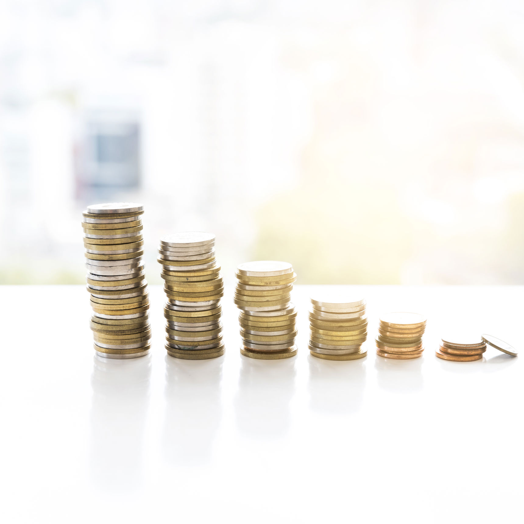 Mønter stabler i seks tårne. Tårnet til venstre er højest. De efterfølgende tårne bliver mindre og mindre.