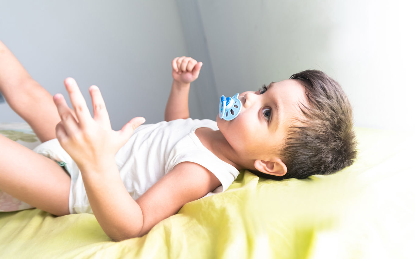 Dreng, der ligger ned med blå sut i munden